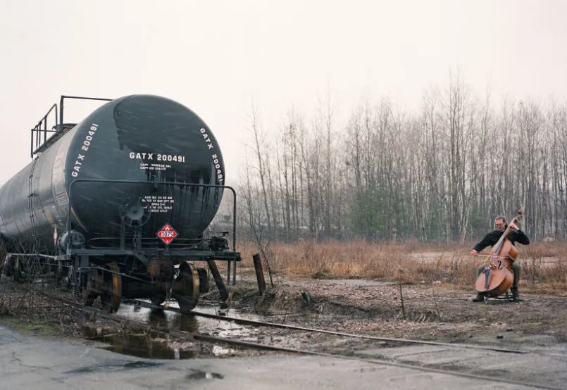 Gahlord Dewald performs with double bass near an old oil tanker car